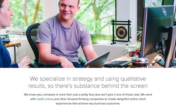 Screenshot of a website — the header image is a white man sitting at a desk smiling at a coworker. The header text reads: We specialize in strategy and using qualitative results, so there's substance behind the screen.